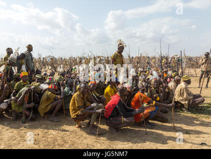 Stamm Krieger während der Zeremonie stolz Ochsen in den Dassanech Stamm, die darauf warten, das Kuh-Fleisch, Turkana County, Omorate, Äthiopien teilen Stockfoto