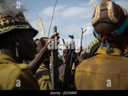 Stamm Krieger während der Zeremonie stolz Ochsen in den Dassanech Stamm, die darauf warten, das Kuh-Fleisch, Turkana County, Omorate, Äthiopien teilen Stockfoto