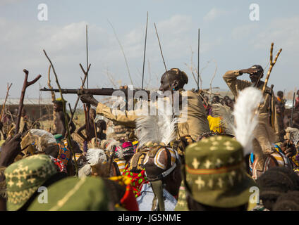 Mann mit einer Kalaschnikow schießen, während der Zeremonie stolz Ochsen in den Dassanech Stamm, Turkana County, Omorate, Äthiopien Stockfoto