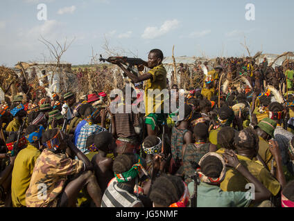 Mann mit einer Kalaschnikow schießen, während der Zeremonie stolz Ochsen in den Dassanech Stamm, Turkana County, Omorate, Äthiopien Stockfoto