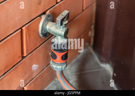 Garten Wasserhahn mit Schlauch attached to it. Stockfoto