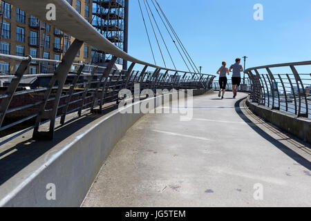 Zwei Menschen Überfahren einer Fußgängerbrücke über einer Bucht des Flusses Themse, schmale Straße, Limehouse, Tower Hamlets, London, UK Stockfoto