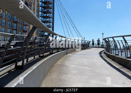 Zwei Menschen Überfahren einer Fußgängerbrücke über einer Bucht des Flusses Themse, schmale Straße, Limehouse, Tower Hamlets, London, UK Stockfoto