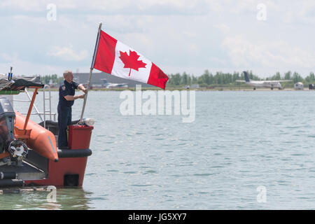 Toronto, Kanada - 26. Juni 2017: Feuerwehrmann Anhebung eine kanadische Flagge am Toronto Harbourfront Stockfoto