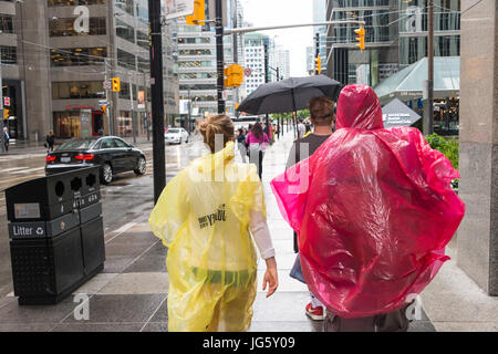 Toronto, Kanada - 26. Juni 2017: Menschenmenge mit Sonnenschirmen und Regenponchos an einem regnerischen Tag Stockfoto