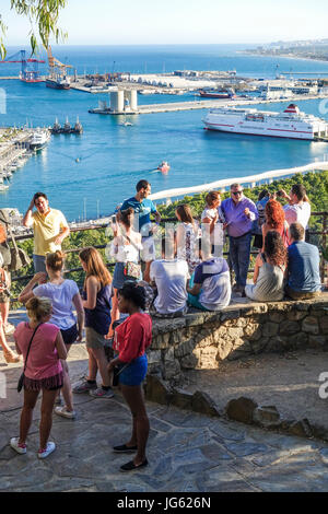 Touristen am Aussichtspunkt Gibralfaro mit Blick auf Hafen von Málaga, Andalusien, Spanien. Stockfoto