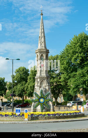 Floral Sonne Symbol Skulptur und bunten Blumenbeet vor Banbury cross, im Licht frühen Morgens. Oxfordshire, England Stockfoto