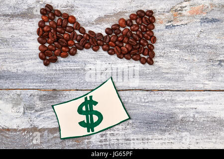 Bogen Sie aus Kaffeebohnen, Zeichnung. Dollarzeichen auf hölzernen Hintergrund. Stockfoto