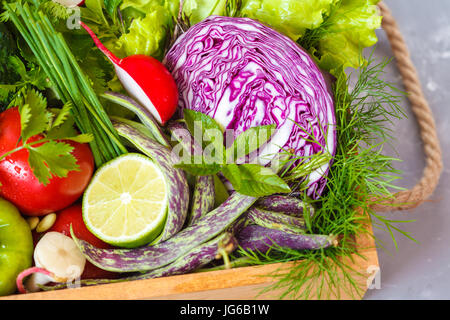 Sommergemüse in einer Holzkiste. Liebe für eine gesunde vegane Ernährung Konzept. Stockfoto