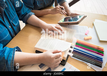 Junge Frau und Mann studieren für einen Test / eine Prüfung. Tutor Bücher mit Freunden Stockfoto