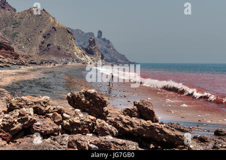Hormuz Insel, Provinz Hormozgan, Iran - 17. April 2017: iranische Insel von Hormuz im Persischen Golf, ein einsamer Reisender Spaziergänge am roten Strand entlang der Stockfoto