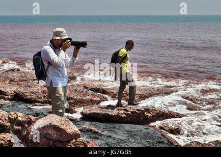 Hormuz Insel, Provinz Hormozgan, Iran - 17. April 2017: zwei Touristen am Strand entlang der Vulkaninsel und fotografieren. Stockfoto