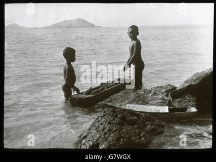 Zwei jungen stehend im Wasser mit einem ausgehöhlten Baumstamm Holz OcG.T.1656 Mana Expedition nach Ost-Polynesien British Museum Stockfoto