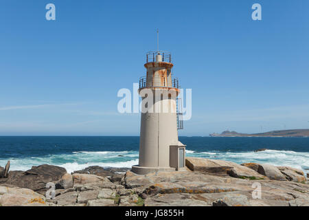 Faro de Muxía (Muxía Leuchtturm) auch bekannt als der Faro de Punta da Barca (Leuchtturm am Punta da Barca) an der Küste des Atlantischen Ozeans, bekannt als der Costa De La Muerte (Todesküste), in der Nähe der Stadt Muxía in Galicien, Spanien. Cabo Vilán ist im Hintergrund zu sehen. Stockfoto