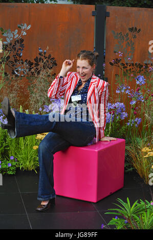 Schaugärten Sie Charlie Bloom, Gartengestalter, sitzen in ihrem Farbe Box Garten, eines der schönen und eleganten auf dem Display an der 2017 RHS Hampton Court Flower Show eröffnet heute auf dem Gelände des Hampton Court Palace, London, Vereinigtes Königreich.  Die RHS Hampton Court Palace Flower Show ist der weltweit größte Blumenschau Prahlerei eine eklektische Mischung von Gärten, Displays und shopping-Möglichkeiten umfasst mehr als 34 Hektar beiderseits des dramatischen lange Wassers mit der beeindruckenden Fassade des historischen Palais im Hintergrund. Rund 130.000 Menschen besuchen jedes Jahr die Messe.  Die Show war erste er Stockfoto