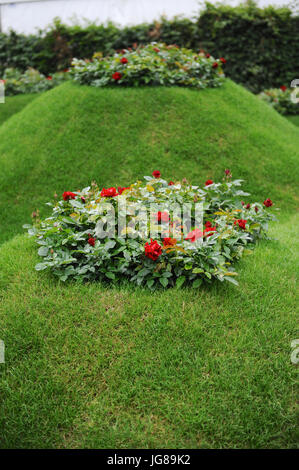RHS Volcanic Rosengarten auf dem Display im Jahr 2017 RHS Hampton Court Flower Show eröffnete die heute London, UK.  Die RHS Hampton Court Palace Flower Show ist der weltweit größte Blumenschau Prahlerei eine eklektische Mischung von Gärten, Displays und shopping-Möglichkeiten umfasst mehr als 34 Hektar beiderseits des dramatischen lange Wassers mit der beeindruckenden Fassade des historischen Palais im Hintergrund. Rund 130.000 Menschen besuchen jedes Jahr die Messe.  Die Show wurde zuerst im Jahre 1990 und erstellt von Historic Royal Palaces und Netzwerk Südost. Für die ersten Hampton Court Palace zeigt legte Netzwerk Südost Stockfoto