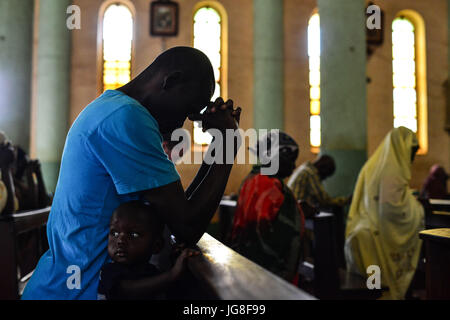 Wau, Wau, Süd-Sudan. 4. Juli 2017. Ein South Sudan IDP-Vater und Sohn beten in der St. Mary helfen Christian Cathedral während des täglichen morgens, die letztes Jahr Service unter der Leitung von Vater Marko Mangu, zuständig für die Diözese für die Stadt von Wau.Â da Auseinandersetzungen zwischen Rebellen und Regierungstruppen ausbrach, ChurchÂ erhielt fast 22 000 Flüchtlinge, meist Bauern, die aus den nördlichen Gebieten des Krieg-Krieg von Dinka Stammesmilizen lief. Bildnachweis: Miguel Juarez Lugo/ZUMA Draht/Alamy Live-Nachrichten Stockfoto