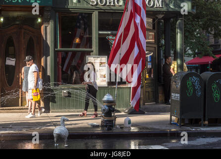 New York, NY, USA. 4. Juli 2017. Am Spring Street in Soho, feierten einige New Yorker Independence Day mit eine riesige amerikanische Flagge, einen offenen Hydranten und eine gefälschte Ente Credit: Stacy Walsh Rosenstock/Alamy Live News Stockfoto