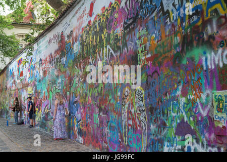 Nur wenige Touristen und ein Straßenmusikant an der John-Lennon-Mauer in Prag. Es ist eine Wand mit Stücken von songtexte von Beatles Songs und John Lennon inspirierten Graffiti. Stockfoto