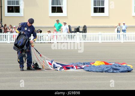 Sandhurst, Surrey, UK - 18. Juni 2017: Fallschirmspringer des RLC Silver Stars Fallschirm Display Team seinen Fallschirm nach der Landung auf dem Parad abrufen Stockfoto