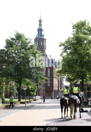 Niederländische Polizisten patrouillieren in den Straßen der Innenstadt von Groningen, Niederlande am Martinikerkhof vom Pferderücken. Stockfoto