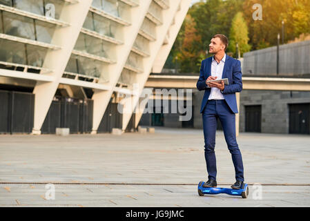 Junger Geschäftsmann Reiten Hoverboard. Stockfoto