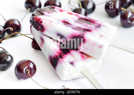 Joghurt und Kirschen Eis am Stiel auf weißem Hintergrund. Erfrischendes Sommer-Dessert. Stockfoto