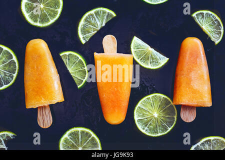 Zuckerfreien orange Eis am Stiel mit Limettenscheiben. Gesunde Sommer-dessert Stockfoto