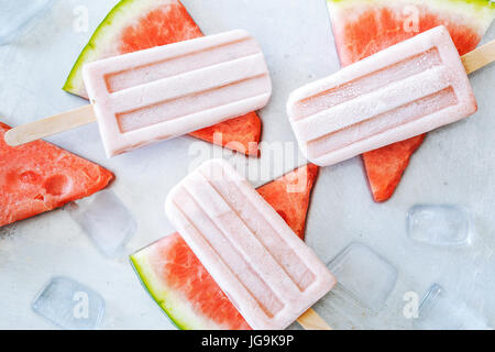 Wassermelone Eis am Stiel auf grauem Hintergrund. Erfrischendes Sommer-Dessert. Stockfoto