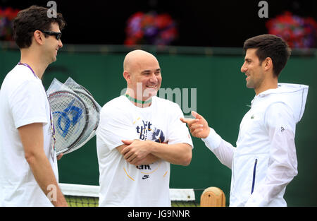 Novak Djokovic mit Trainer Andre Agassi und Mario Ancic (links) am zweiten Tag der Wimbledon Championships in The All England Lawn Tennis and Croquet Club, Wimbledon. Stockfoto