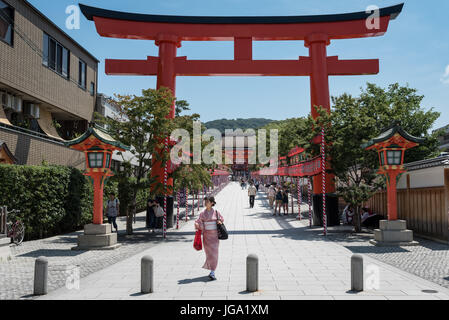 Frau im Kimono in Fushimi Inari Torii Toren in Kyoto, Japan Stockfoto