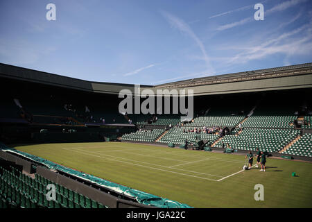 Das Bodenpersonal bereitet am dritten Tag der Wimbledon Championships im All England Lawn Tennis and Croquet Club, Wimbledon, den Mittelplatz vor. Stockfoto