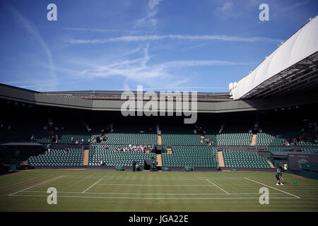 Bodenpersonal vorbereiten Centrecourt am dritten Tag der Wimbledon Championships in The All England Lawn Tennis and Croquet Club, Wimbledon. Stockfoto