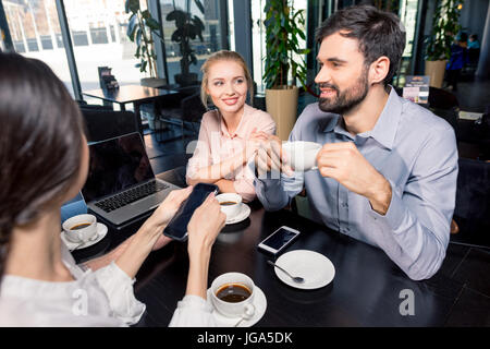 Business-Team treffen diskutieren Projekt mit Laptop und Smartphones im Café, Business-Lunch-Konzept Stockfoto