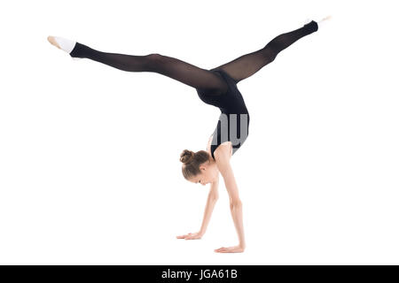 Sportliche junge Frau in Sportkleidung tun Handstand isoliert auf weiss Stockfoto