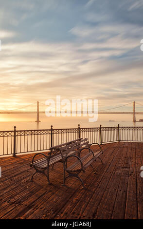 Sonnenaufgang über die Bay Bridge und der Mole im Hafenviertel von San Francisco, USA Stockfoto