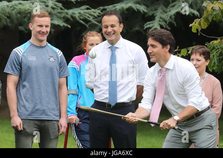 Der kanadische Premierminister Justin Trudeau, beobachtet von Dublin GAA Fußballer Ciaran Kilkenny, probiert einen Hurling-Stick auf dem Gelände des Farmleigh House in Dublin, nach einer Pressekonferenz mit irischen Taoiseach Leo Varadkar. Stockfoto
