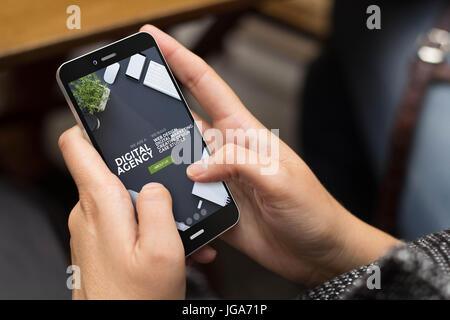 Mobile Design-Konzept: Mädchen mit einem digital generierten Telefon mit coolen Digitalagentur Website auf dem Bildschirm. Alle Bildschirm-Grafiken bestehen. Stockfoto