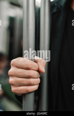 Nahaufnahme eines Jünglings kaukasischen Reisen als Passagier in einem Waggon, stehend und packte einen senkrechten Strich mit seiner rechten hand Stockfoto