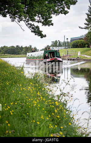 Schmale Boot mit zwei Personen an Bord reisen entlang Bridgewater Kanals in der Nähe von Daresbury internationalen Wissenschafts- und Technologiepark Stockfoto