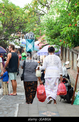 Bali, Indonesien - 21. April 2016. Balinesischen Frauen gehen im Zentralmarkt in Bali, Indonesien. Bali ist ein beliebtes Touristenziel, das eine s gesehen hat Stockfoto