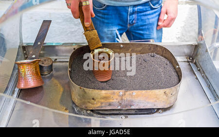Die traditionellen türkischen Kaffee kochen in cezve auf dem heißen Sand in der Altstadt von Tiflis, Georgien. Stockfoto