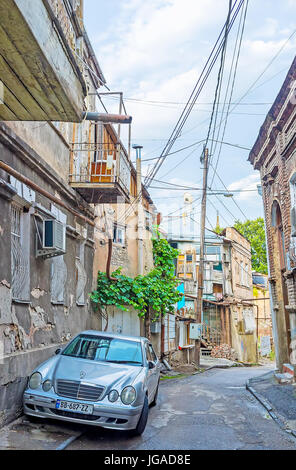 Tiflis, Georgien - 5. Juni 2016: Die geparkten Auto unter den verlassenen Häusern in der Altstadt, am 5. Juni in Tiflis. Stockfoto