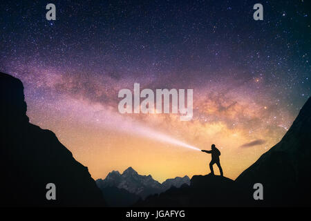 Silhouette von dem Mann in den Bergen mit einer Taschenlampe in der Hand. Nepal, Everest-Region, Blick auf den Mount Thamserku. Stockfoto