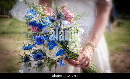 Ein Brautstrauß Blumen durch eine Braut an ihrem Hochzeitstag gemacht von Gartenblumen mit aus Fokus Kanten statt Nahaufnahme Stockfoto