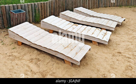 Leeren weißen hölzernen Strand Liegestühle an einem sandigen Flussufer.  Regnerischen bewölkten Tag der kurze Sommerurlaub Stockfoto