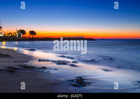 Sonnenuntergang über dem Meer und Welle waschen bis zum Strand, Langzeitbelichtung Stockfoto
