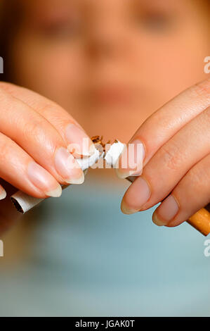 Nahaufnahme einer Frau Hände brechen eine Zigarette in halbe, Stop-Smoking-Konzept Stockfoto