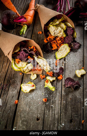 Bio-Ernährung essen. Die vegane Ernährung. Getrocknetes Gemüse. Hausgemachte Chips aus Rüben, Karotten und Zucchini. Auf alten rustikalen Holztisch mit frischem Gemüse Stockfoto