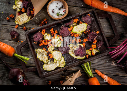 Bio-Ernährung essen. Die vegane Ernährung. Getrocknetes Gemüse. Hausgemachte Chips aus Rüben, Karotten und Zucchini. Auf alten rustikalen Holztisch mit frischem Gemüse Stockfoto